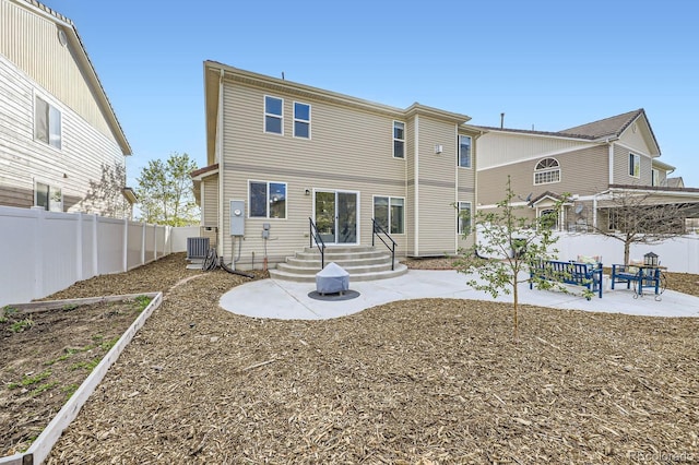 back of property featuring a fenced backyard, entry steps, a patio area, and central AC