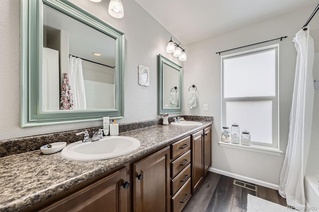 5072 Cathay St, Denver, CO 80249 - bathroom featuring double vanity, wood finished floors, shower / tub combo with curtain, and baseboards