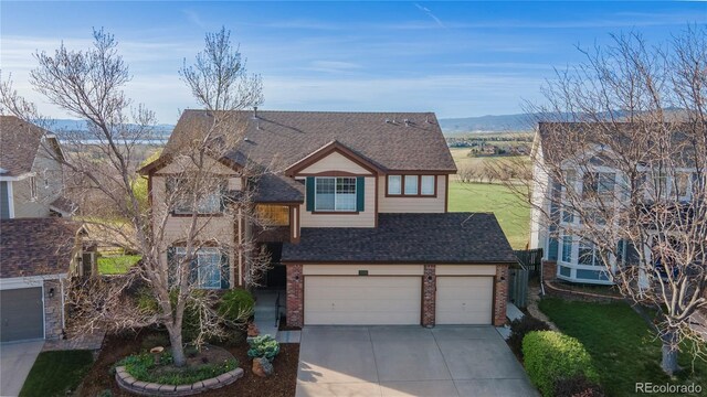 9586 W Victoria Dr, Littleton, CO 80128 - traditional-style house with brick siding, driveway, a garage, a front lawn, and a shingled roof