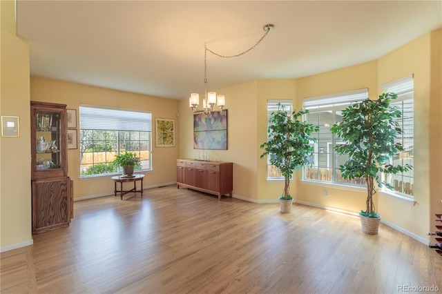 9586 W Victoria Dr, Littleton, CO 80128 - dining area with an inviting chandelier, a wealth of natural light, baseboards, and wood finished floors
