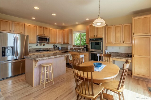 9586 W Victoria Dr, Littleton, CO 80128 - kitchen with a kitchen island, stainless steel appliances, light brown cabinets, and a sink