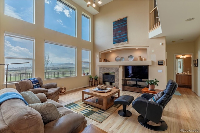 9586 W Victoria Dr, Littleton, CO 80128 - living area with a towering ceiling, a glass covered fireplace, and wood finished floors