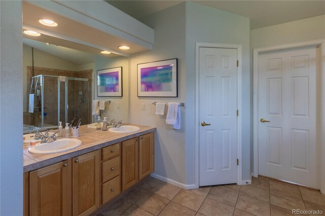 9586 W Victoria Dr, Littleton, CO 80128 - full bathroom featuring a stall shower, tile patterned floors, double vanity, and a sink