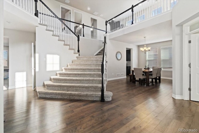 3745 Spanish Oaks Trl, Castle Rock, CO 80108 - stairway featuring a high ceiling, hardwood / wood-style flooring, and a chandelier