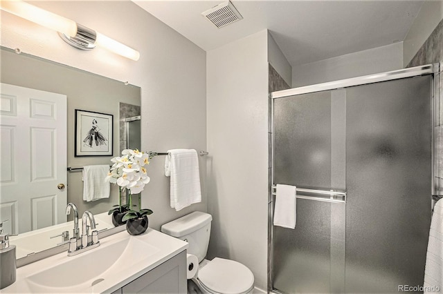 bathroom with vanity, an enclosed shower, and toilet