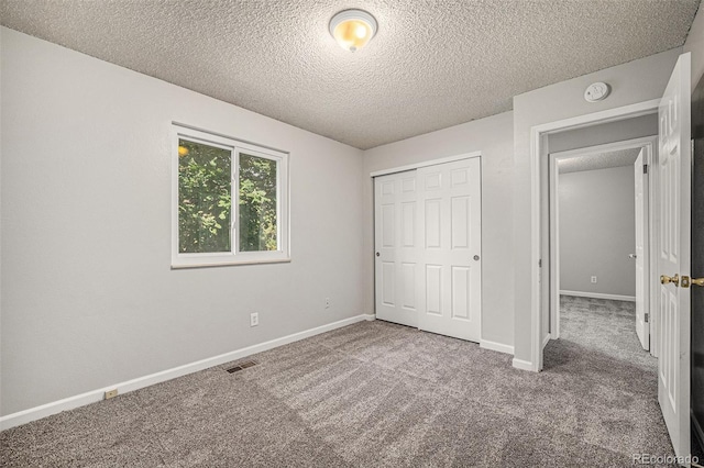 unfurnished bedroom with a closet, carpet, and a textured ceiling