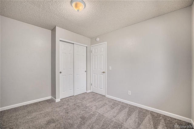 unfurnished bedroom with carpet flooring, a textured ceiling, and a closet