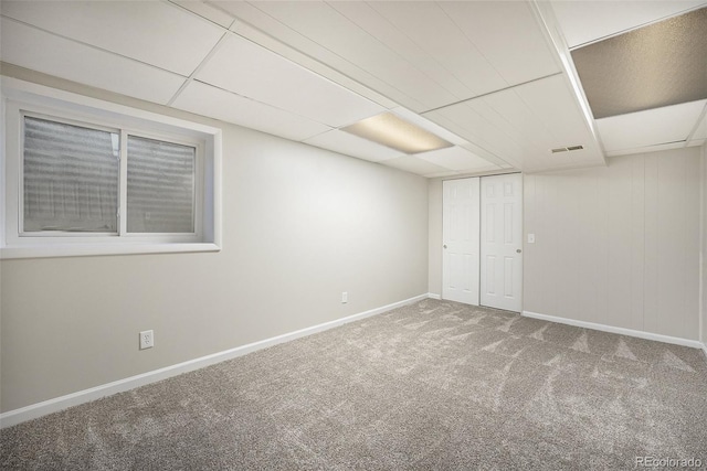 interior space featuring a paneled ceiling and carpet floors