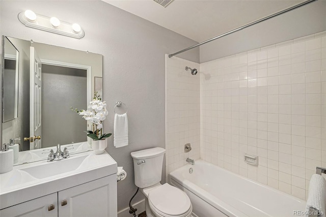 full bathroom with tiled shower / bath, vanity, and toilet