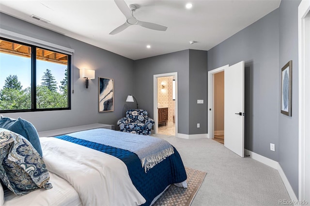 bedroom featuring light carpet, ceiling fan, and ensuite bathroom