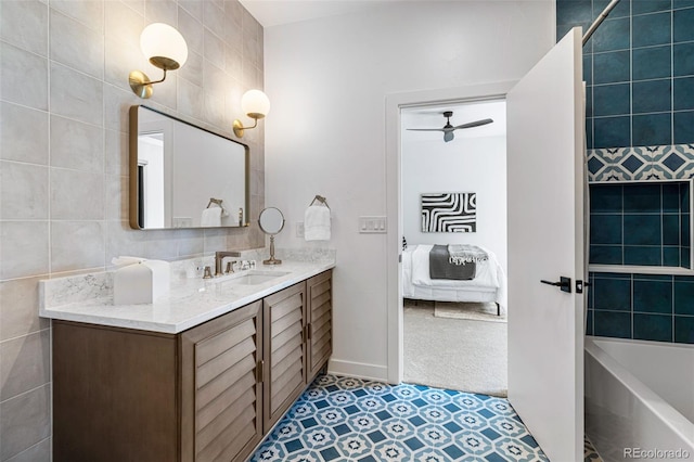 bathroom featuring ceiling fan, vanity, and tile walls