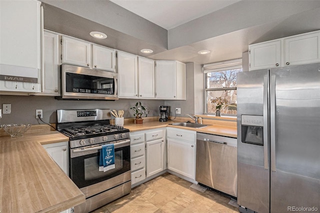 kitchen featuring white cabinetry, appliances with stainless steel finishes, light countertops, and a sink