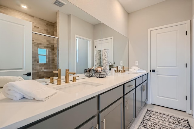 bathroom featuring tile patterned flooring, vanity, and walk in shower