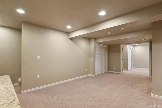 finished basement featuring light colored carpet, baseboards, and recessed lighting