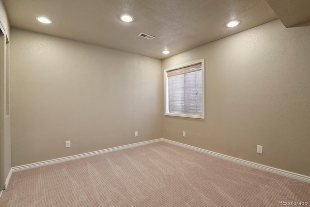 unfurnished room with baseboards, light carpet, visible vents, and recessed lighting
