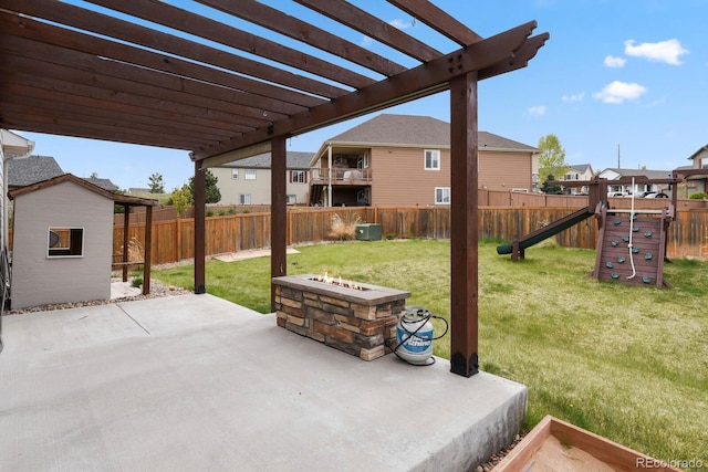 view of patio featuring a fenced backyard, a pergola, a playground, and a fire pit