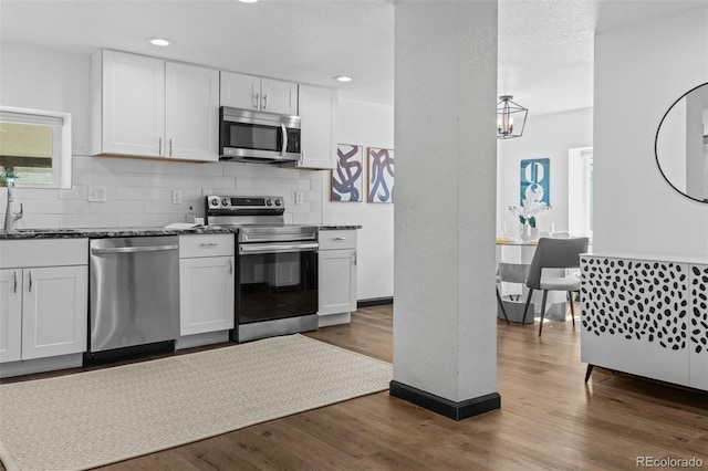 3275 W Hawthorne Pl, Denver, CO 80221 - kitchen featuring stainless steel appliances, decorative backsplash, white cabinets, and recessed lighting