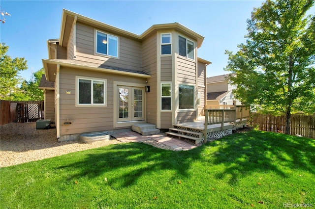 rear view of property with a yard and a deck