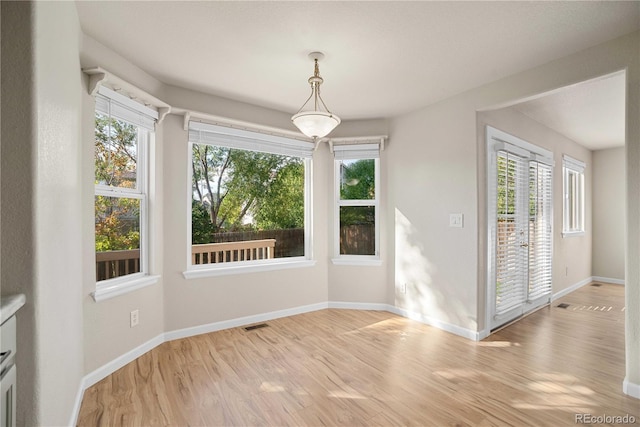 unfurnished dining area featuring light wood-type flooring