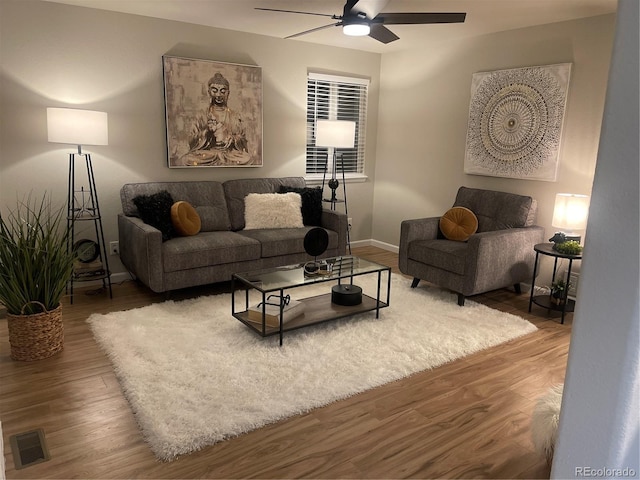 living room featuring wood-type flooring and ceiling fan