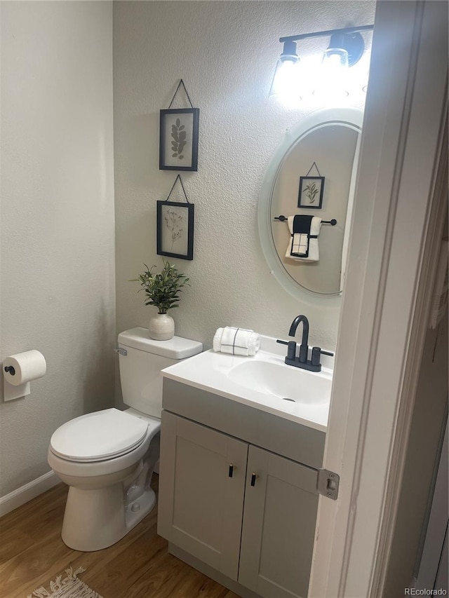 bathroom featuring hardwood / wood-style flooring, vanity, and toilet