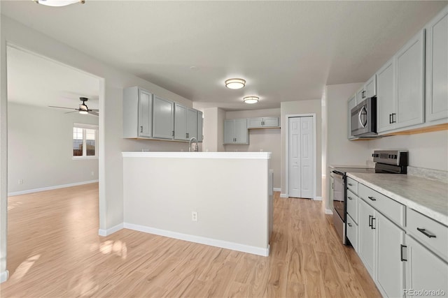 kitchen featuring sink, gray cabinetry, appliances with stainless steel finishes, ceiling fan, and light hardwood / wood-style floors