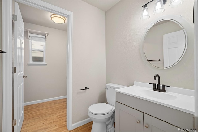 bathroom featuring wood-type flooring, toilet, and vanity