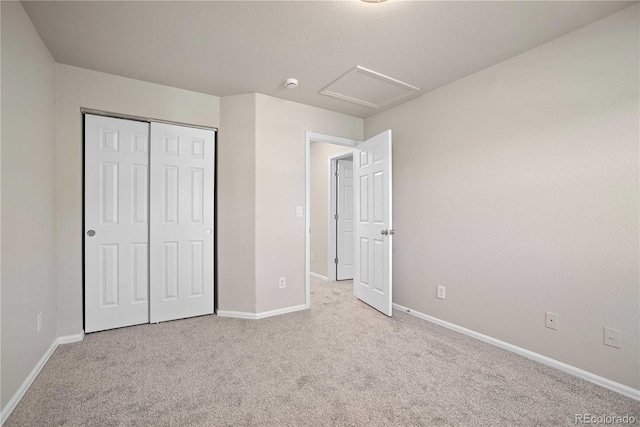 unfurnished bedroom featuring light colored carpet and a closet