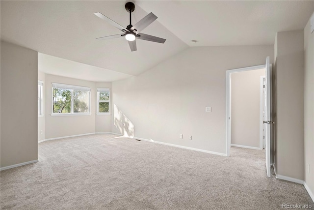 empty room with lofted ceiling, light carpet, and ceiling fan