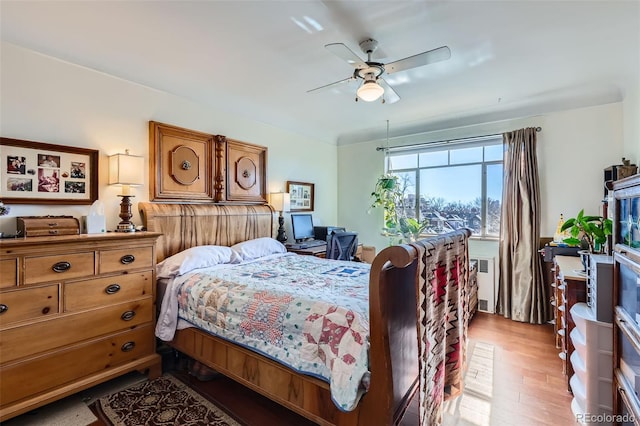 bedroom featuring radiator, a ceiling fan, and light wood-style floors