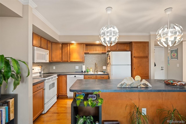 kitchen featuring decorative light fixtures, sink, ornamental molding, a notable chandelier, and white appliances