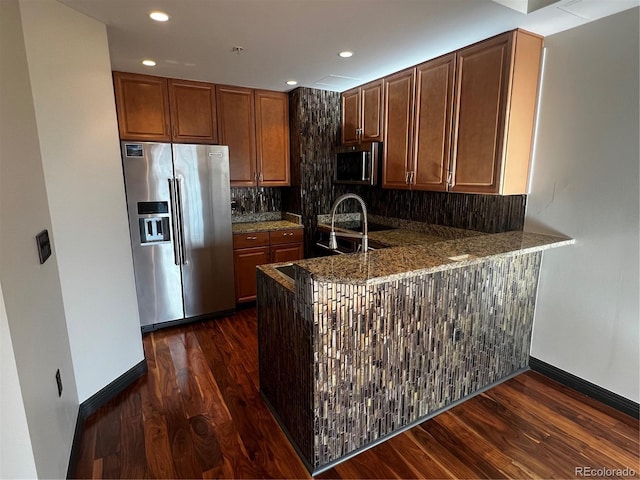 925 N Lincoln St Unit 14C, Denver, CO 80203 - kitchen with stainless steel appliances, dark wood-style flooring, tasteful backsplash, baseboards, and a peninsula