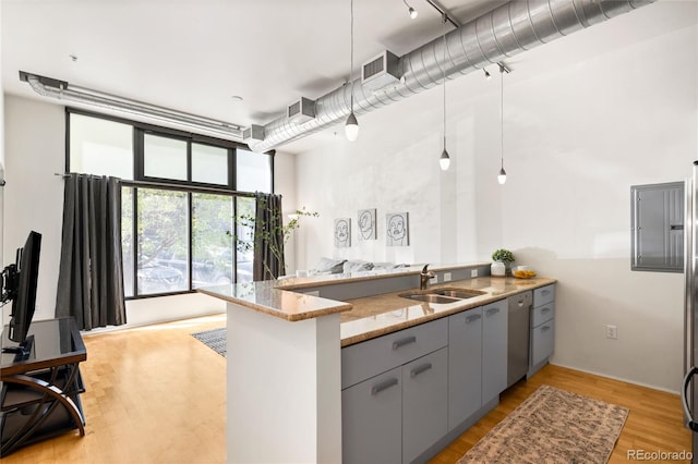 kitchen featuring a sink, light stone counters, gray cabinetry, a peninsula, and dishwashing machine