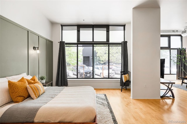 bedroom with light wood-style flooring and multiple windows