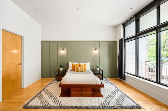 bedroom featuring a decorative wall and light wood finished floors