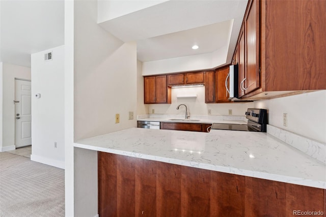 kitchen with light stone countertops, kitchen peninsula, sink, and appliances with stainless steel finishes