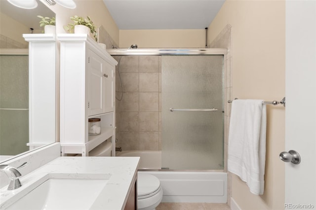 full bathroom with shower / bath combination with glass door, tile patterned flooring, vanity, and toilet