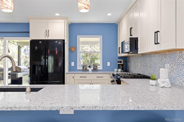 15000 W 29th Ave, Golden, CO 80401 - kitchen with black appliances, decorative backsplash, light stone countertops, recessed lighting, and white cabinetry