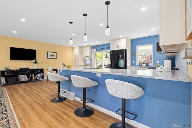 15000 W 29th Ave, Golden, CO 80401 - kitchen featuring black refrigerator with ice dispenser, a sink, white cabinetry, light stone counters, and recessed lighting