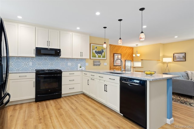 15000 W 29th Ave, Golden, CO 80401 - kitchen featuring black appliances, a sink, a peninsula, open floor plan, and light wood-style flooring