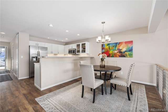 dining space with dark wood-style floors, recessed lighting, a chandelier, and baseboards