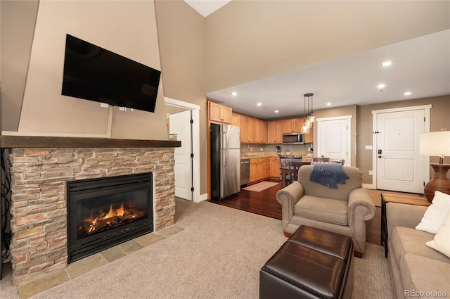 living room with a stone fireplace and light wood-type flooring