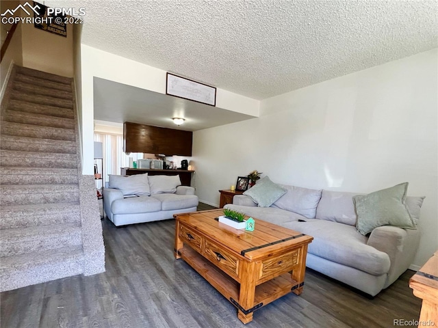 living room with dark hardwood / wood-style flooring and a textured ceiling