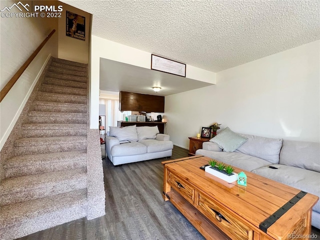 living room featuring dark hardwood / wood-style floors and a textured ceiling