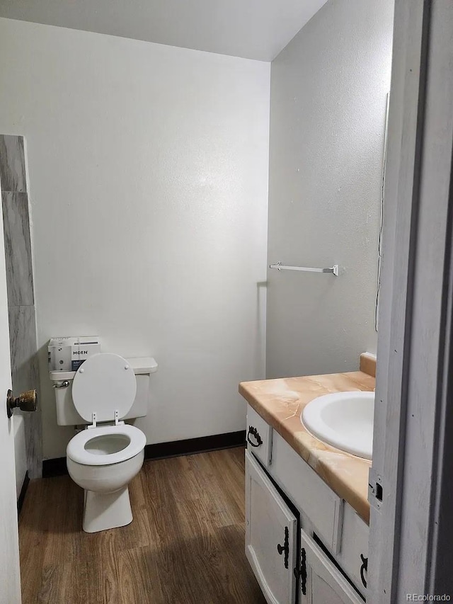 bathroom with vanity, toilet, and wood-type flooring