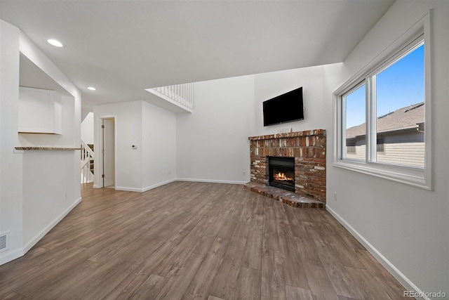4246 S Granby St Unit B, Aurora, CO 80014 - unfurnished living room featuring wood finished floors, a brick fireplace, recessed lighting, and stairs