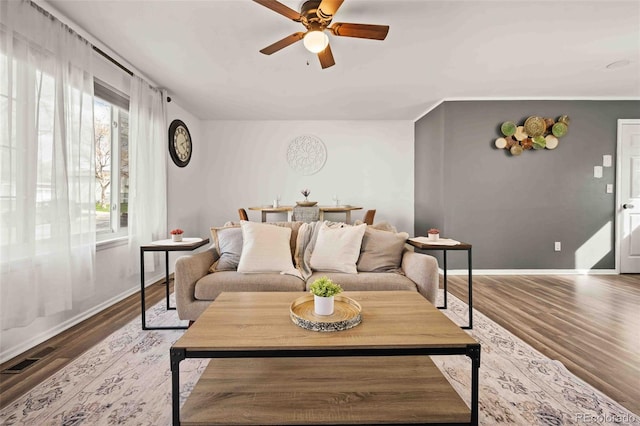 living room with wood finished floors, baseboards, and ceiling fan