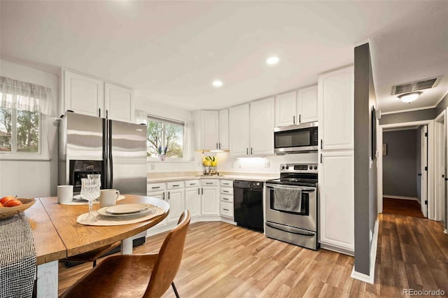 kitchen with stainless steel appliances, visible vents, recessed lighting, light wood-style flooring, and white cabinetry