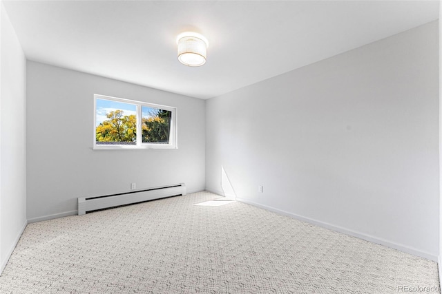 empty room featuring a baseboard heating unit and light colored carpet