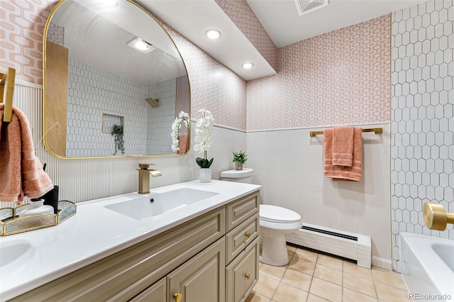 full bathroom featuring a baseboard heating unit, toilet, vanity, tiled shower / bath combo, and tile patterned flooring